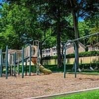 A playground with a yellow slide and green metal bars.